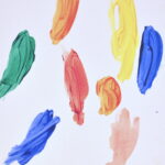 Abstract painting on white background of 8 thick and short brush-strokes. Colors included are green, blue, orange, red, yellow, and pink.