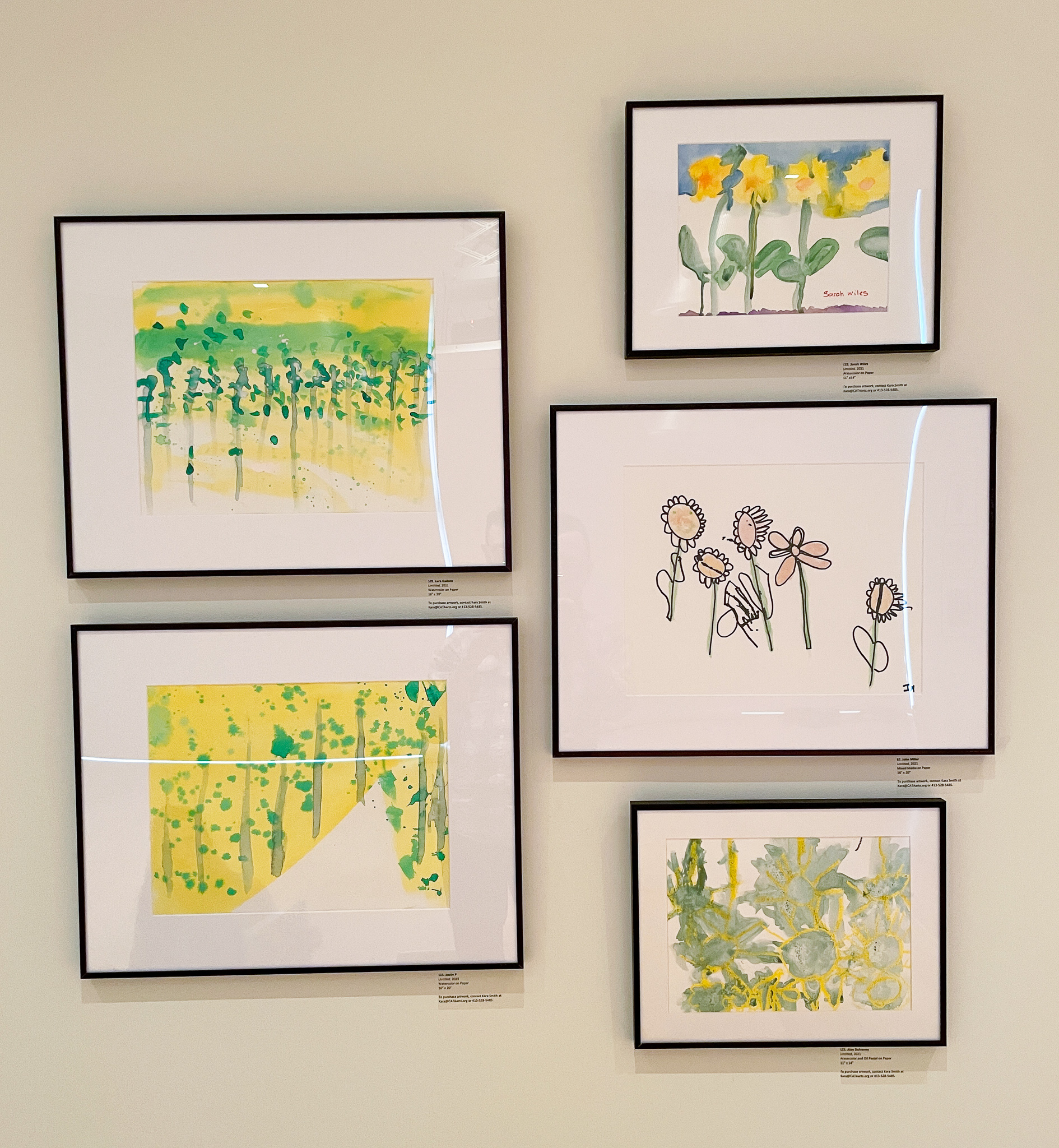Gallery wall with five paintings in tones of green and yellow