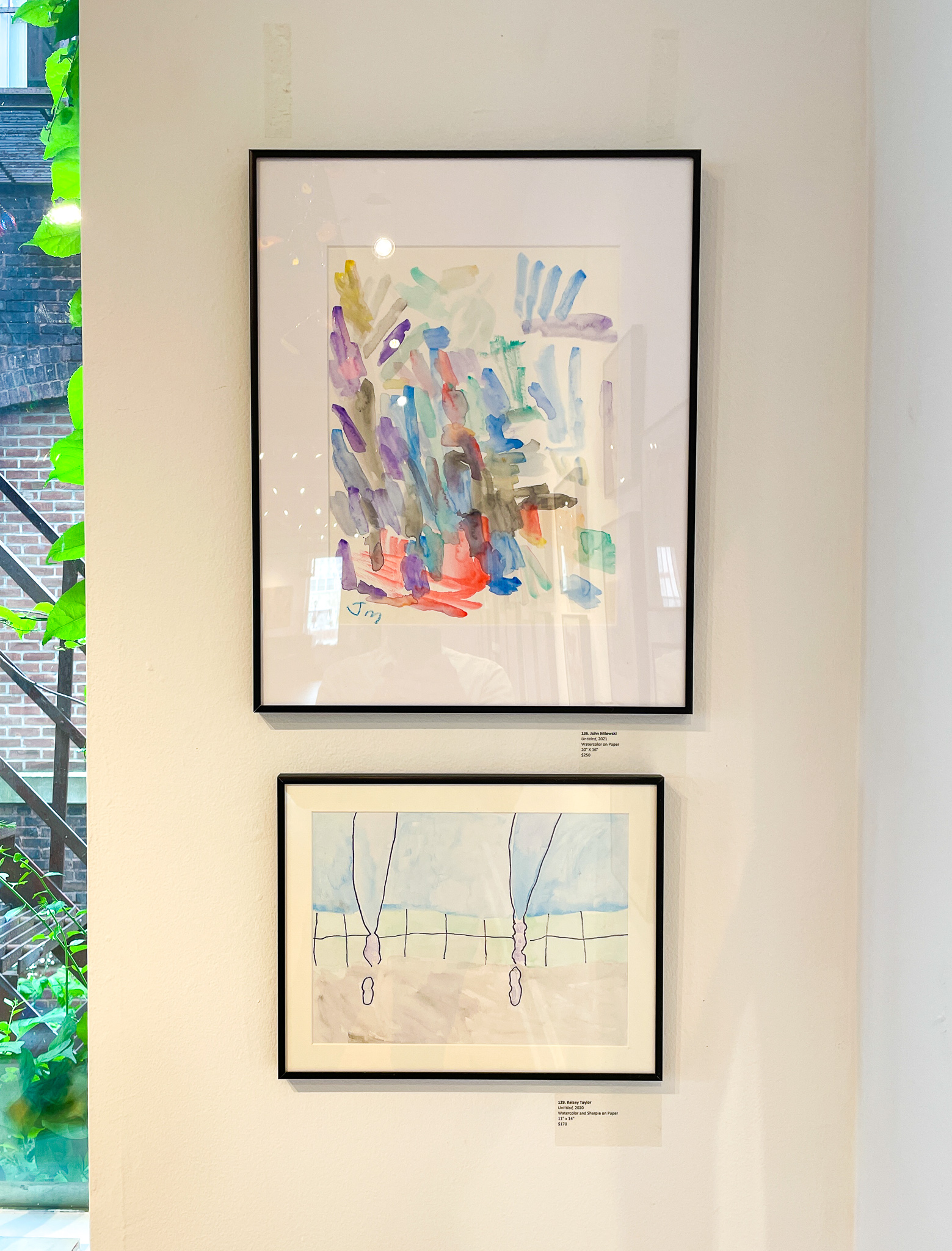 Gallery wall with two colorful abstract paintings in black frames