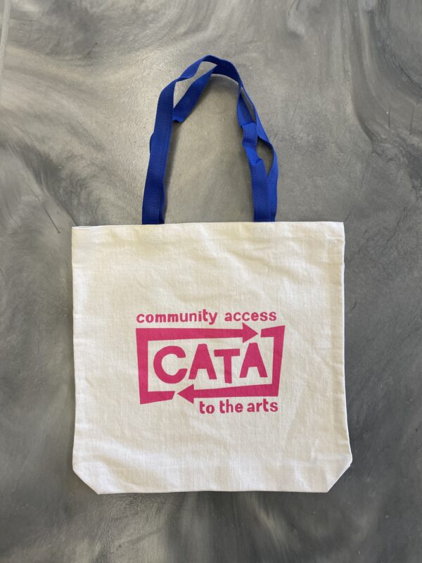 Image description: Tote bag with bright blue handles and pink CATA logo