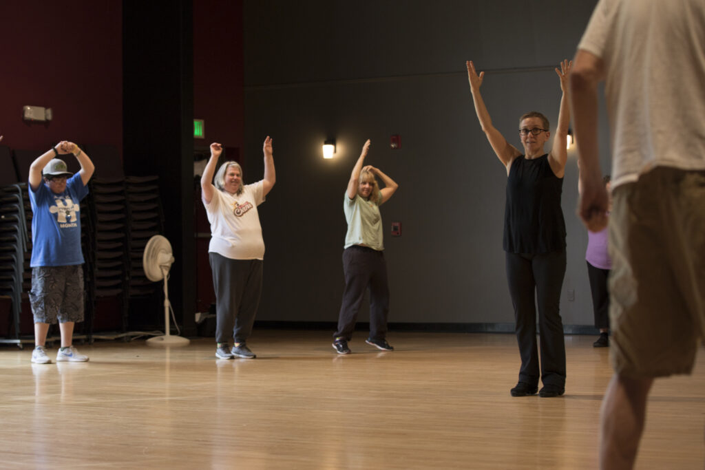 Dawn Lane holds her hands in the air during a dance workshop