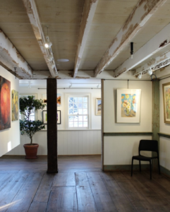 Image description: A gallery with big windows and art hanging on the walls