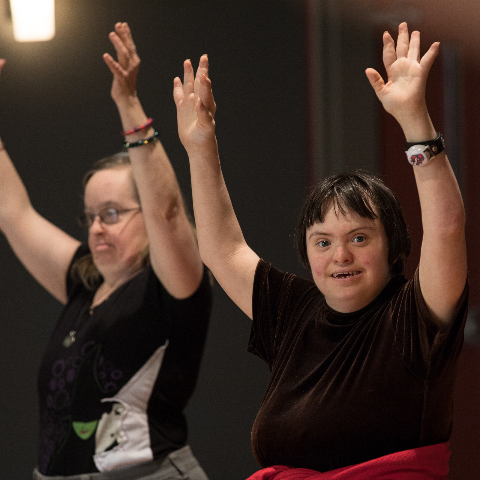 CATA artists hold hands above their heads in a dance class