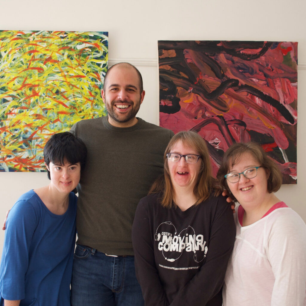 Teresa posed alongside three other people with large paintings in the background.