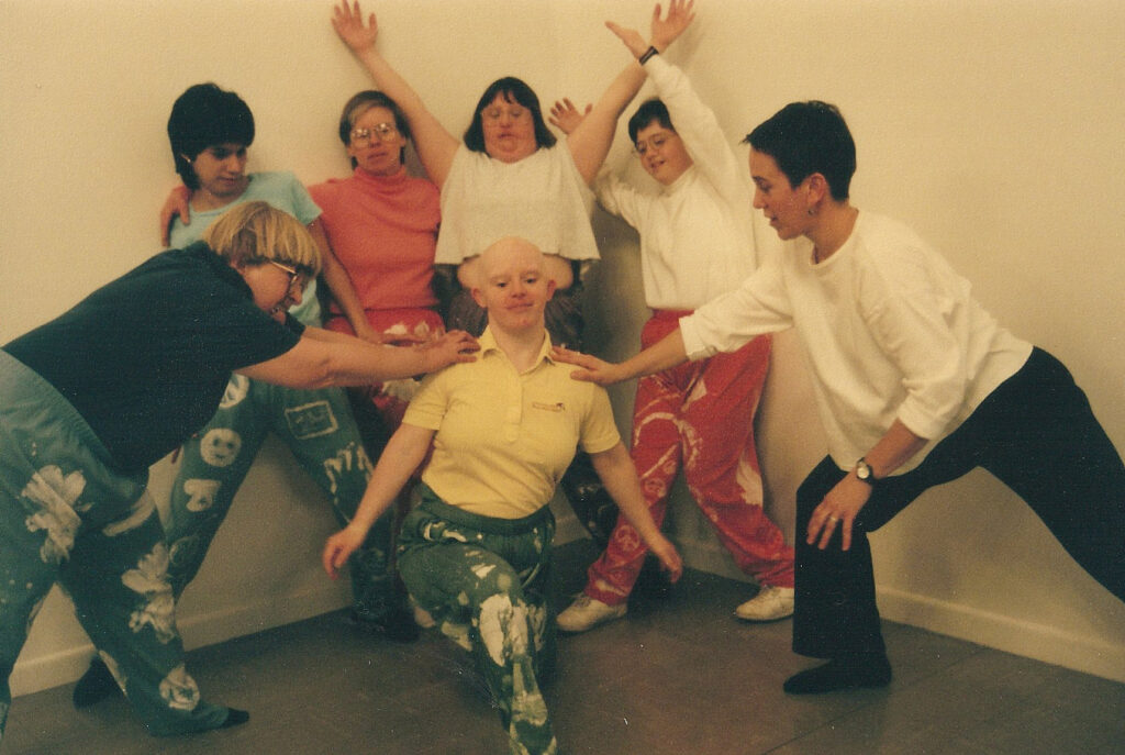 A group of dancers pose together wearing matching costumes.