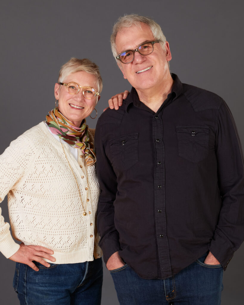 A headshot of Caitlin and Mitch Nash standing in front of a grey background.