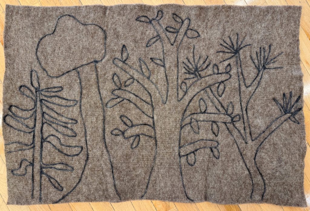 An outline of trees on a felt panel.