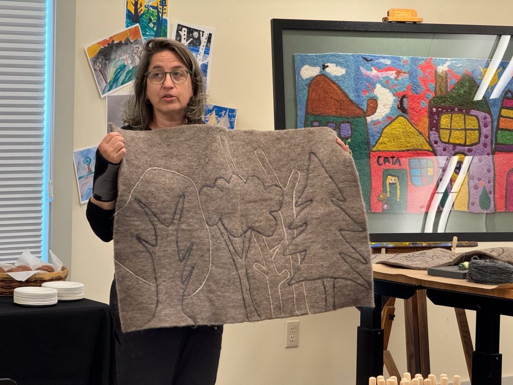 Janet holds up the outline of felted trees.