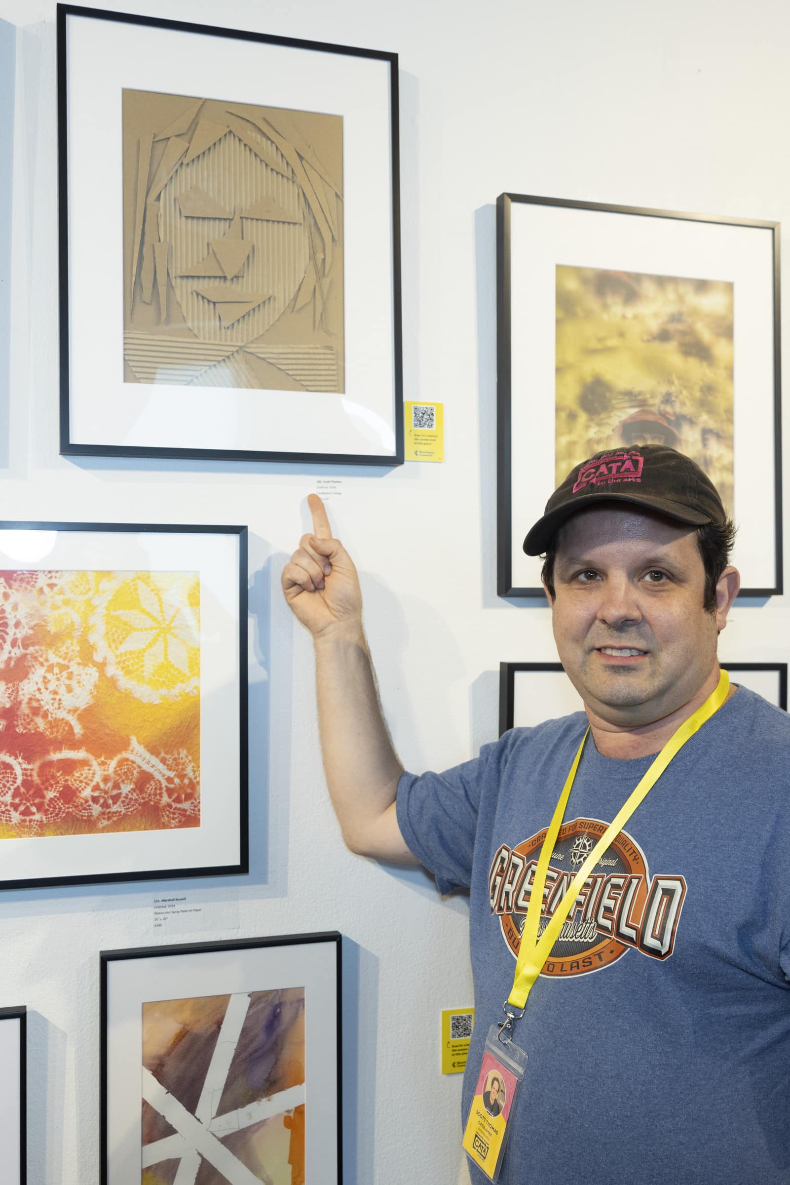 A CATA artist points to his cardboard collage.