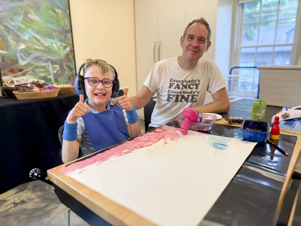 A young boy and his father make art together.