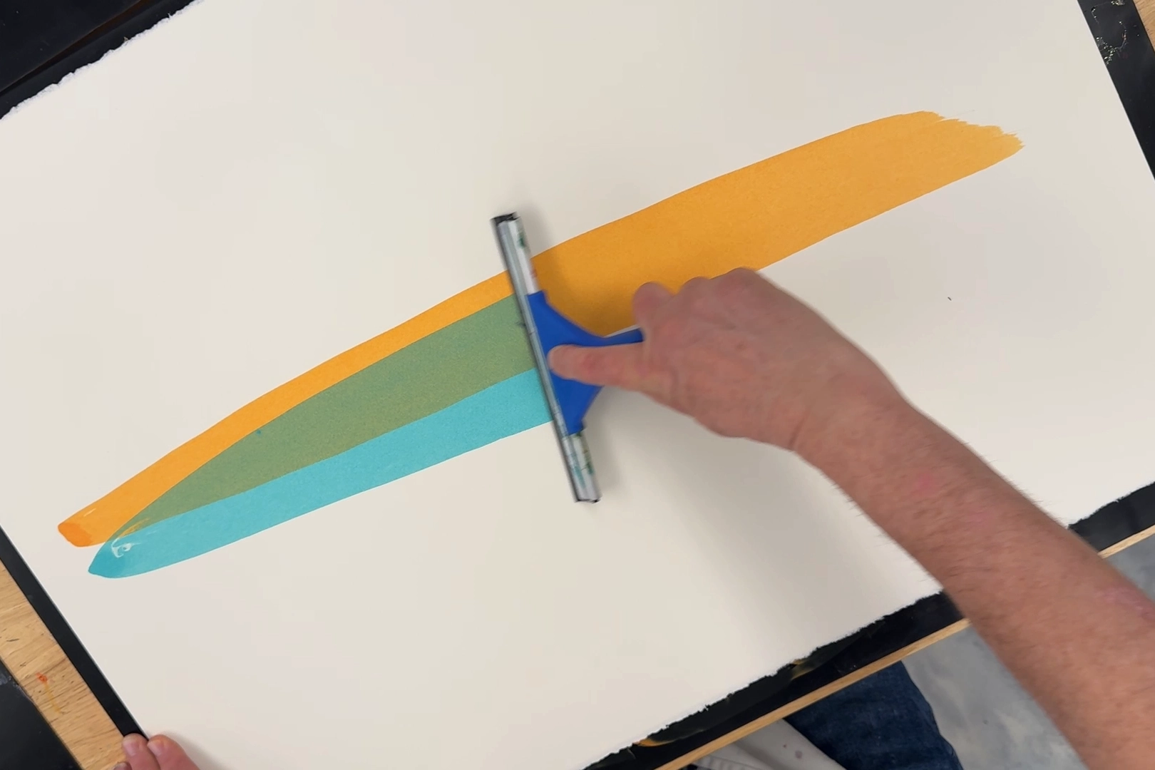 Blue paint washes over yellow, creating green.