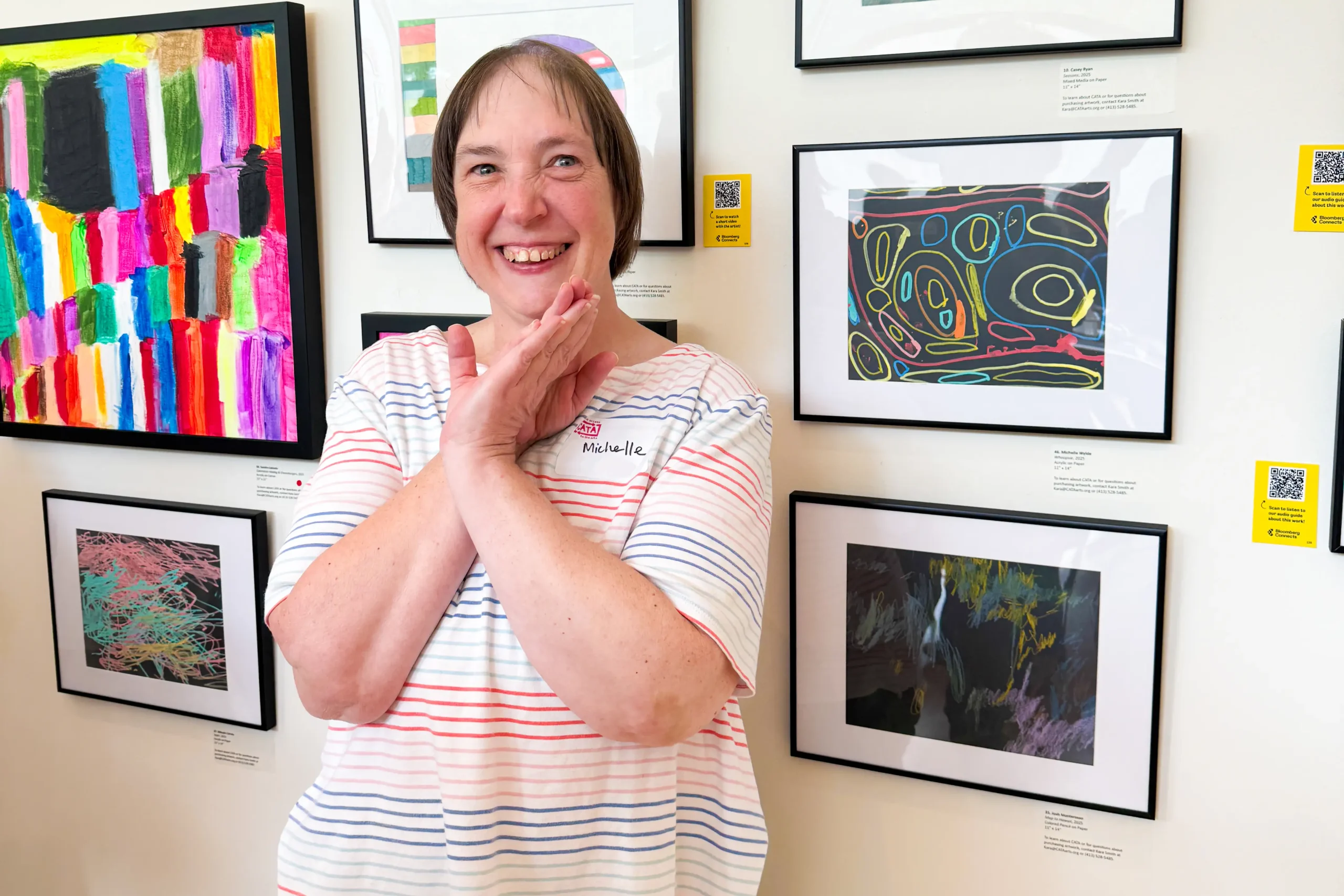 Michelle (BFAIR) beams at her drawing displayed in a CATA exhibit.